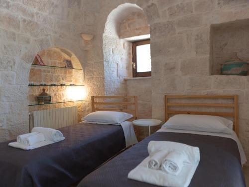 a bedroom with two beds with towels on them at Trulli holiday home with private pool near Ostuni in Ostuni