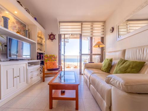 Una sala de estar con un sofá y un televisor. en Apartment Solarium III by Interhome, en Torredembarra