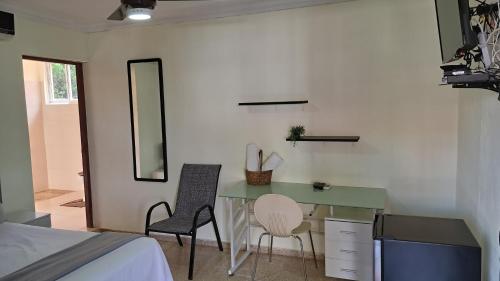 1 dormitorio con escritorio, 2 sillas y 1 cama en D9 Casa de Huespedes, en Santo Domingo