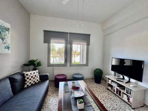 a living room with a couch and a tv at Golden Key apartments in Chania
