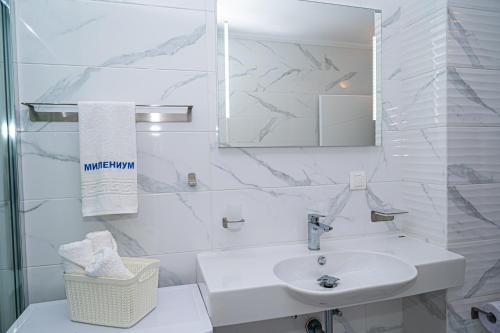 een witte badkamer met een wastafel en een spiegel bij Sea View Apartment with Free Parking in Pomorie