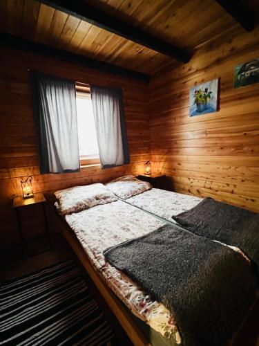 a bedroom with a bed in a log cabin at Domki u Bejdaka in Bereżnica Wyżna