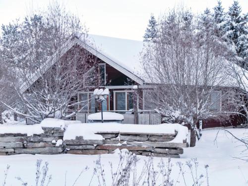 une maison recouverte de neige avec un mur en pierre dans l'établissement Holiday Home Villa milla by Interhome, à Tahkovuori