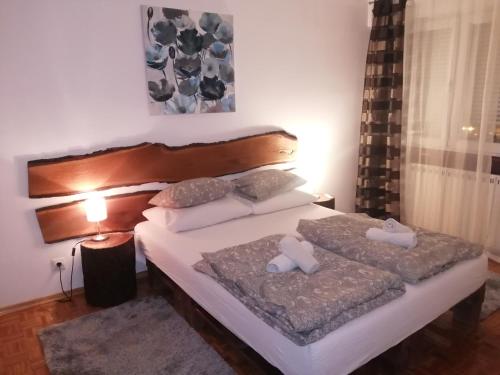 a bedroom with two beds and a lamp at Apartman Stonewood West in Zagreb