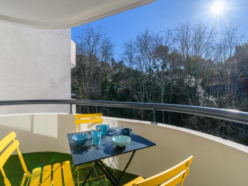 stół na balkonie z żółtymi krzesłami w obiekcie Apartment Feodorowka-2 by Interhome w Arcachon