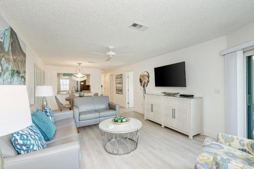 a living room with a couch and a tv at Absolute Anna Maria-Private Beach Access-Heated Pool-Water Views From Every Room in Bradenton Beach