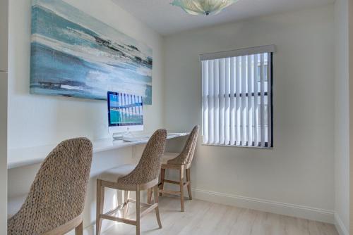 a room with a desk with two chairs and a computer at Absolute Anna Maria-Private Beach Access-Heated Pool-Water Views From Every Room in Bradenton Beach
