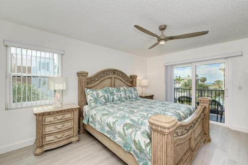 1 dormitorio con 1 cama y ventilador de techo en Absolute Anna Maria-Private Beach Access-Heated Pool-Water Views From Every Room, en Bradenton Beach