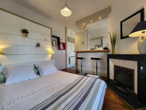 - une chambre avec un lit blanc et une cheminée dans l'établissement Stop Chez M Style # Qualité # Confort # Simplicité, à Lyon