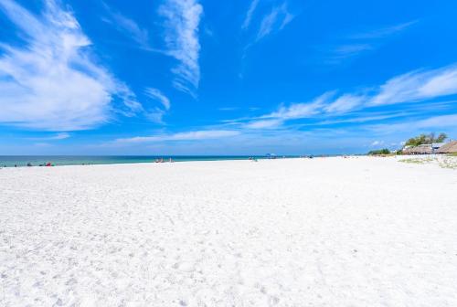 a beach with white sand and a blue sky at Absolute Anna Maria-Private Beach Access-Heated Pool-Water Views From Every Room in Bradenton Beach