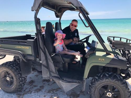 a man and a little girl sitting in a jeep at the beach at Absolute Anna Maria-Private Beach Access-Heated Pool-Water Views From Every Room in Bradenton Beach