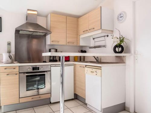- une cuisine avec des appareils blancs et des armoires en bois dans l'établissement Studio Camijeanne by Interhome, à Capbreton