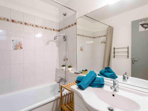 une salle de bain avec un lavabo, une baignoire et un miroir dans l'établissement Studio Vostok Zodiaque-91 by Interhome, au Corbier