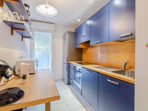 une cuisine avec des placards bleus et un comptoir en bois dans l'établissement Apartment Le Clos Saint Saens-3 by Interhome, à Saint-Aygulf