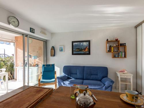 un salon avec un canapé bleu et une table dans l'établissement Apartment Terre Marine-1 by Interhome, à Sanary-sur-Mer