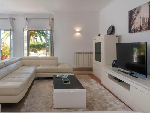 a living room with a couch and a flat screen tv at Holiday Home Girassol by Interhome in Cascais