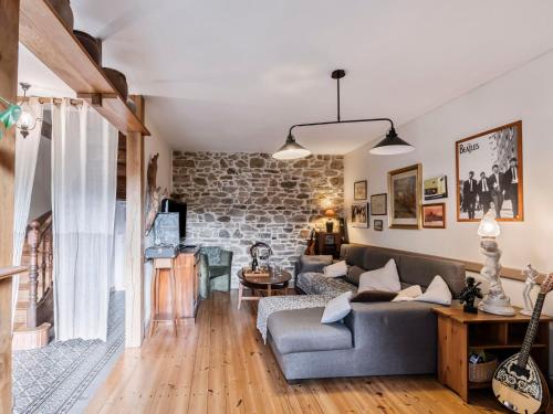 un salon avec un canapé et un mur en pierre dans l'établissement Holiday Home Les Roses by Interhome, à Yffiniac