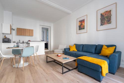 un salon avec un canapé bleu et une table dans l'établissement Le Puits d'Argent - Spacieux T2 au Coeur de Nantes, à Nantes