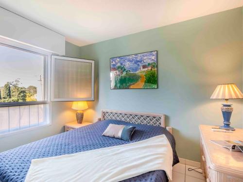 une chambre avec un lit et deux lampes et une fenêtre dans l'établissement Apartment Le Promethée by Interhome, à Saint-Raphaël