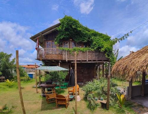 a small house with a deck and chairs in front of it at Casa de Terra in Caraíva