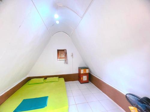 Habitación pequeña con cama y ventana en Sumatra Thomas Leaf Monkey Guesthouse & Jungle Trek en Bukit Lawang