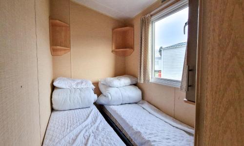 A bed or beds in a room at 8 Berth Caravan With Wifi At Seawick Holiday Park Ref 27025r