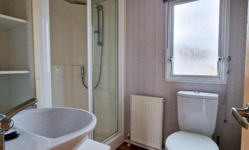 a bathroom with a shower and a sink and a toilet at 8 Berth Caravan With Wifi At Seawick Holiday Park Ref 27025r in Clacton-on-Sea