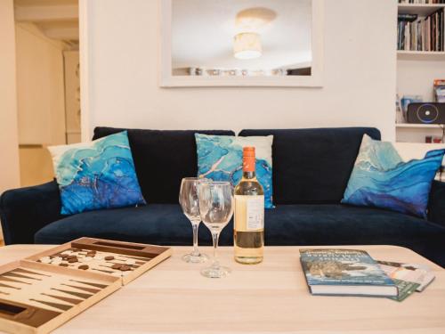 uma garrafa de vinho e um copo sobre uma mesa em Holiday Home Cliff Cottage by Interhome em Mevagissey