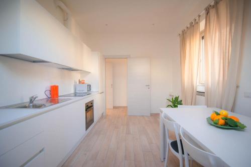 a kitchen with a table with a bowl of fruit on it at Comonfive Apartments in Como