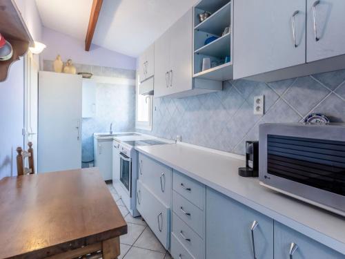 une cuisine avec des armoires blanches et un comptoir dans l'établissement Apartment L'Olivastre by Interhome, au Lavandou