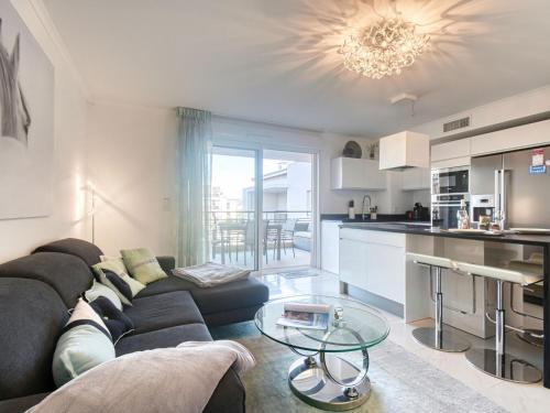 un salon avec un canapé noir et une cuisine dans l'établissement Apartment Le 4 Mats-2 by Interhome, à Fréjus
