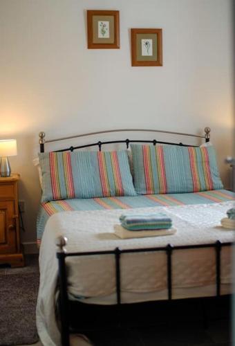 a bed with two pillows on top of it at Mary Jane's Cottage, Lettermacaward in Doochary