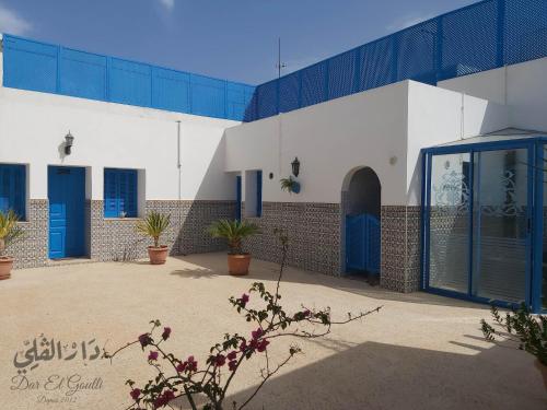 un edificio con puertas azules y plantas en un patio en Dar El Goulli, en Sousse