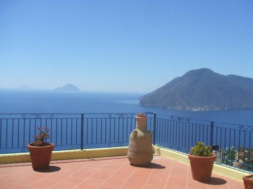 three pots sitting on a balcony overlooking the ocean at Villa Panorama in Lipari