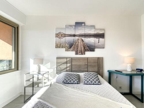 sypialnia z łóżkiem i zdjęciem na ścianie w obiekcie Apartment Le Méditerranée-3 by Interhome w Fréjus