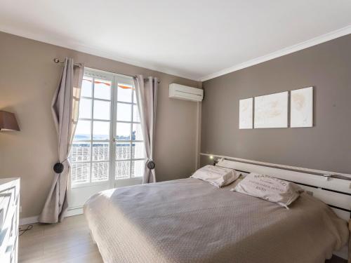 une chambre avec un lit et une grande fenêtre dans l'établissement Apartment Mont des Oiseaux-2 by Interhome, à Hyères