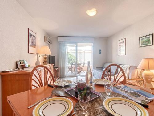 - une salle à manger avec une table en bois et des assiettes dans l'établissement Apartment Le Consul-2 by Interhome, à Fréjus