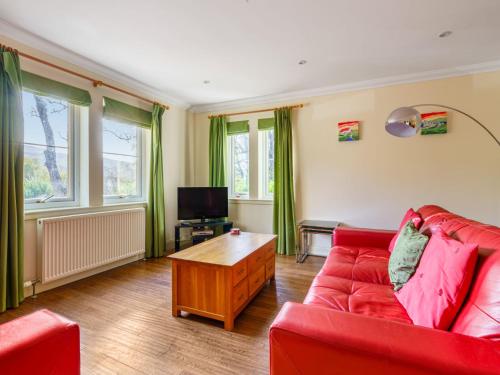 sala de estar con sofá rojo y mesa en Holiday Home Brocks by Interhome, en Drumnadrochit