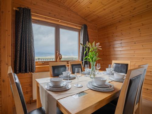 comedor con mesa, sillas y ventana en Chalet Loch Leven Lodge 10 by Interhome en Kinross