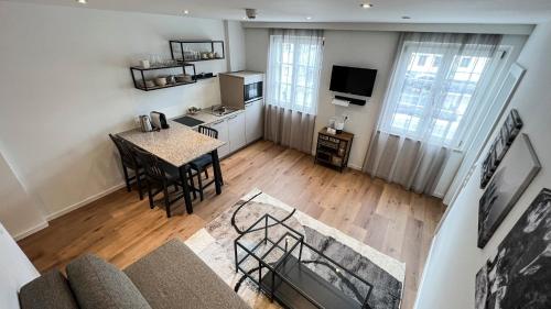 eine Luftansicht auf eine Küche und ein Wohnzimmer mit einem Tisch in der Unterkunft City Zimmer - Appartement Dina Mariner in Lienz