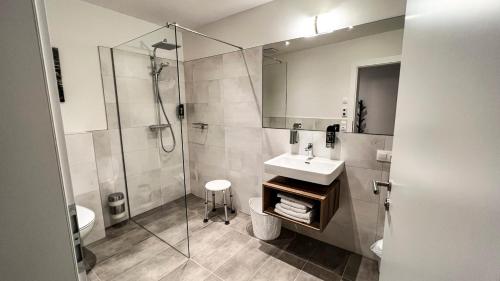 een badkamer met een wastafel en een douche bij City Zimmer - Appartement Dina Mariner in Lienz