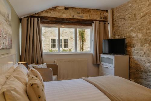 a bedroom with a bed and a window and a television at Little England Retreats - Cottage, Yurt and Shepherd Huts in Othery