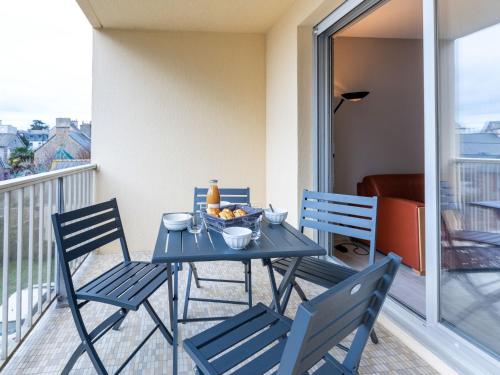 een blauwe tafel met stoelen en een schaal fruit op een balkon bij Apartment Le Galion-2 by Interhome in Dinard