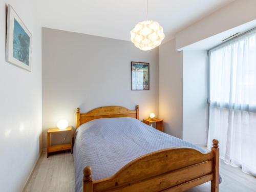 een slaapkamer met een houten bed en een raam bij Apartment Le Galion-2 by Interhome in Dinard