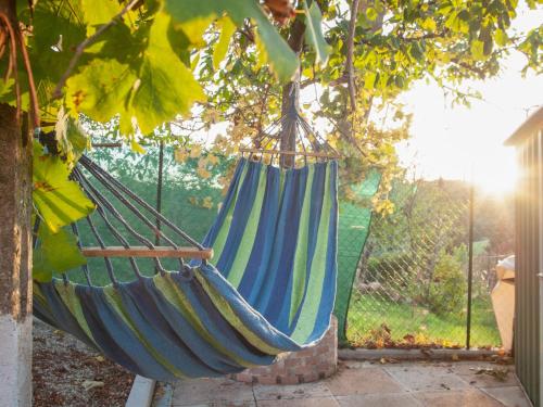 una hamaca azul y verde colgada de un árbol en Apartment Casa Alessia by Interhome, en Tavarnelle in Val di Pesa