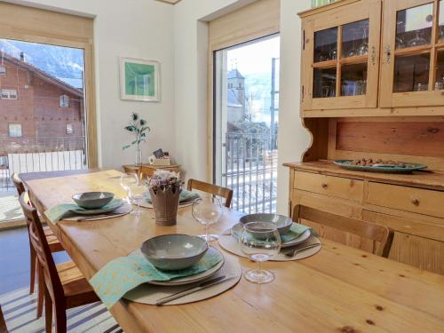 een houten tafel met borden en wijnglazen erop bij Holiday Home Hofstatt by Interhome in Ringgenberg