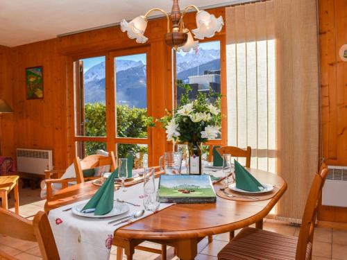 una sala da pranzo con tavolo, sedie e finestra di Apartment Rüthanet by Interhome ad Airolo