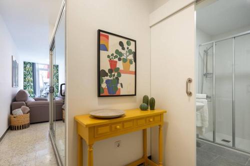 un bagno con un tavolo giallo e un quadro sul muro di Puccini Oasis - Sole e amore a Las Palmas de Gran Canaria