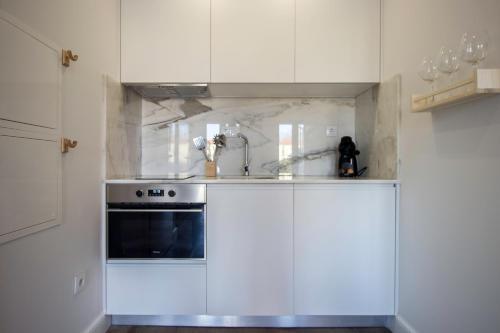 a kitchen with white cabinets and a stove at Guest H4U - Porto Bonfim Heroismo in Porto