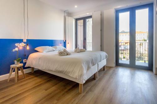 1 dormitorio con 1 cama grande y pared azul en Guest H4U - Porto Bonfim Heroismo, en Oporto